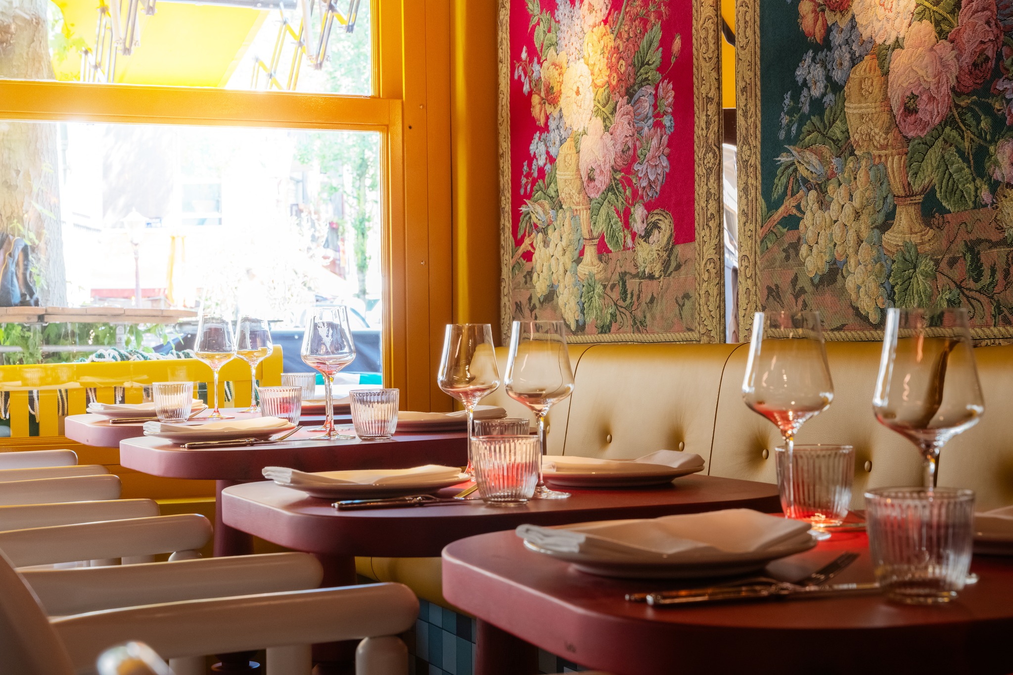 Yellow interior of Salut with set tables by the window on Gerard Douplein in De Pijp