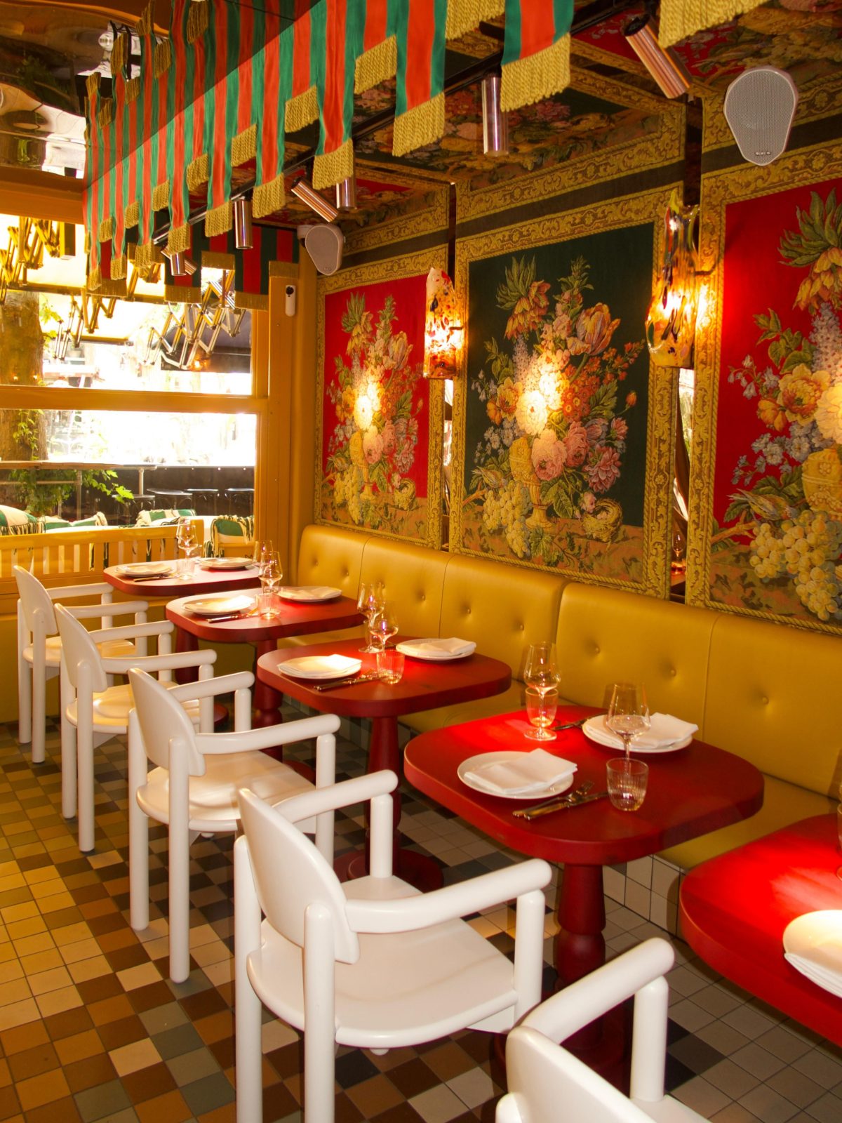 Interior of Salut with floral panels, banquettes and set tables, designed by Jean-Philippe Demeyer