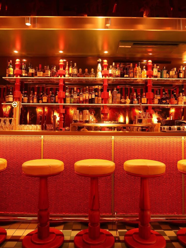De bar van Salut met gele barkrukken en een rode bar aan het Gerard Douplein in De Pijp, Amsterdam
